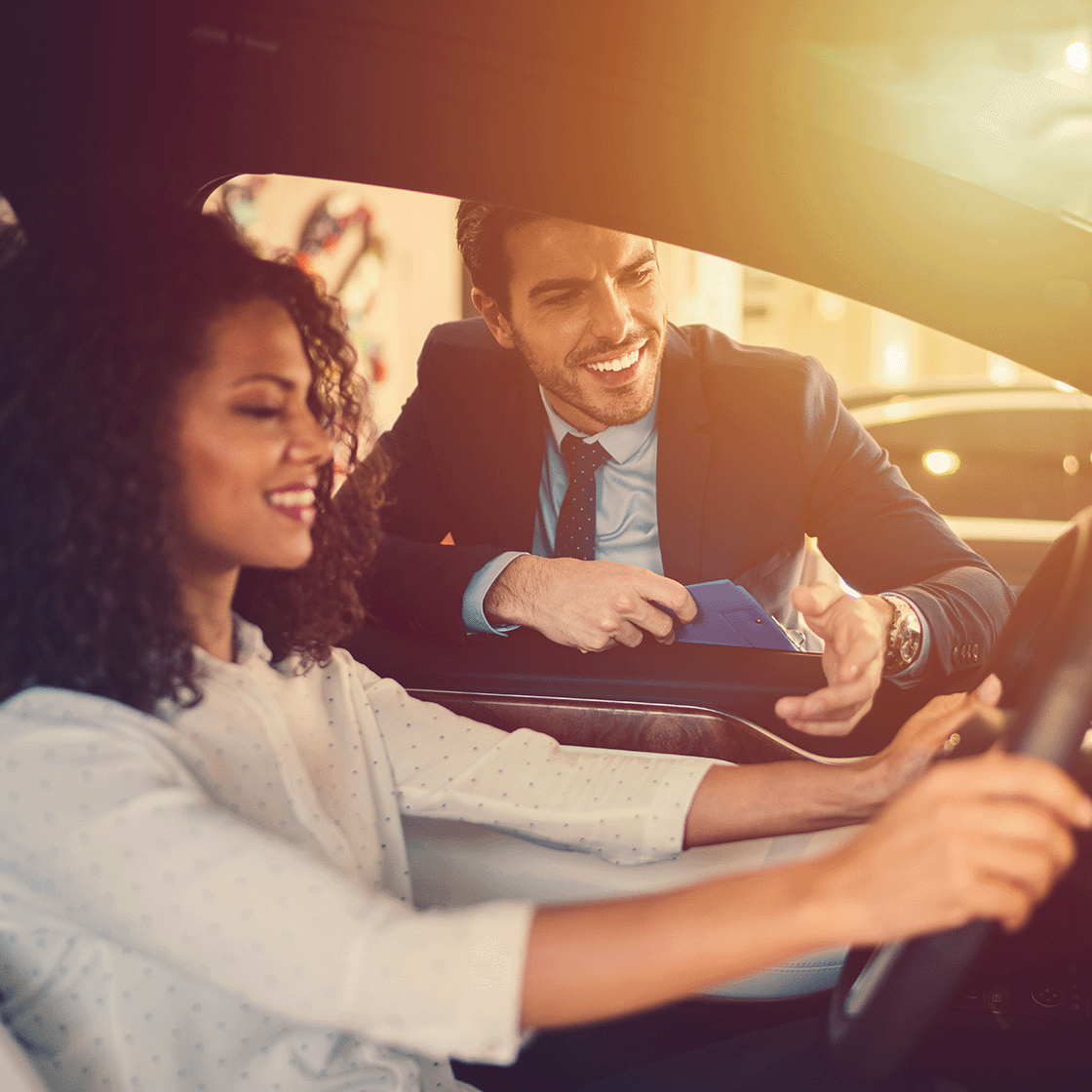 Salesman explaining the car to smiling woman